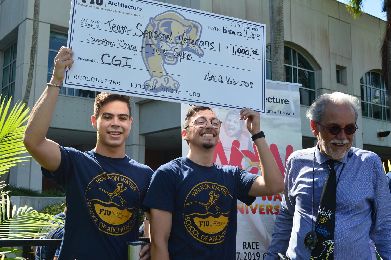 FIU students hold up sponsorship check for Walk on Water competition